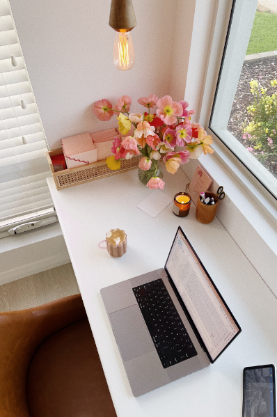 Bureau de travail avec fleurs et ordinateur portable